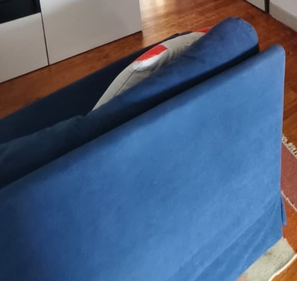 Sofá azul com marcas de uso