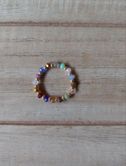 Pierścinek ze szklanych koralików na żyłce elastycznej.