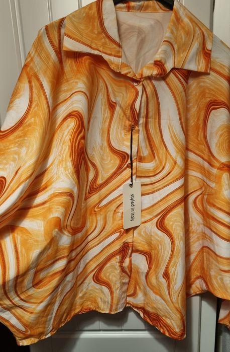 Camisa em tons laranja, tecido acetinado, mangas morcego. Oversized