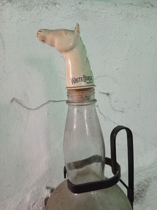 Suporte em ferro e garrafa de whisky.