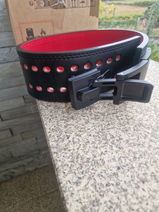 cinto de musculação e powerlifting com fivela de alavanca (lever belt), com cerca de 13 mm de espessura, em pele preta com o interior vermelho