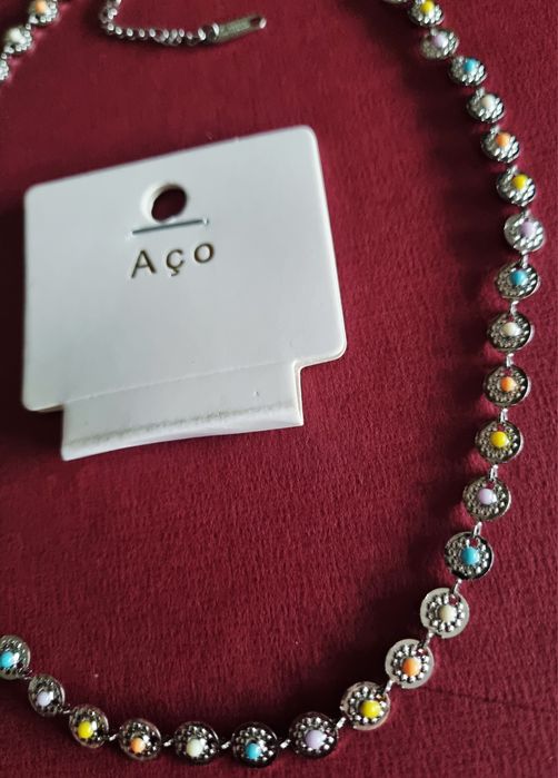 Colar/gargantilha prateado, em aço, com pequenas bolinhas coloridas. T