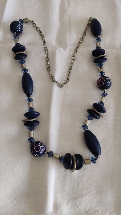 Colar  azul com desenhos em algumas contas.