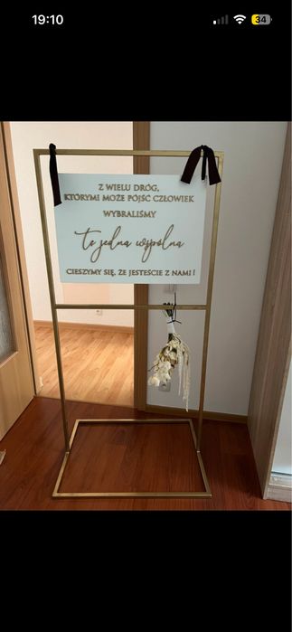 Zloty stojak z tablicą powitalną