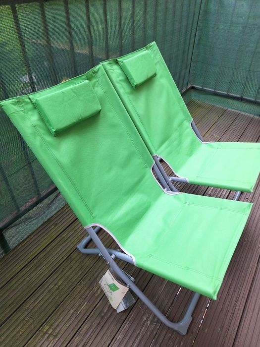 Dwa zielone leżaki używane