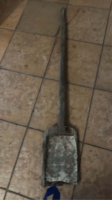 antiga pá de madeira e metal com um cabo longo, tradicionalmente utilizada na agricultura para manusear cereais, batatas ou palha