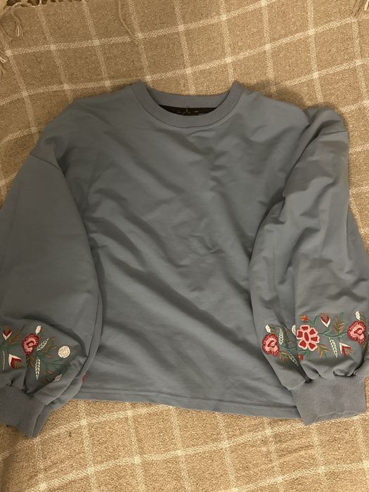 Светр з традиційною нашивкою на рукавах у стилі вишиванки