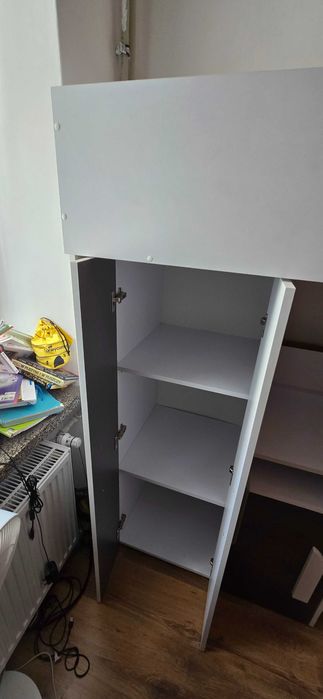 Łóżko piętrowe z biurkiem i szafą.