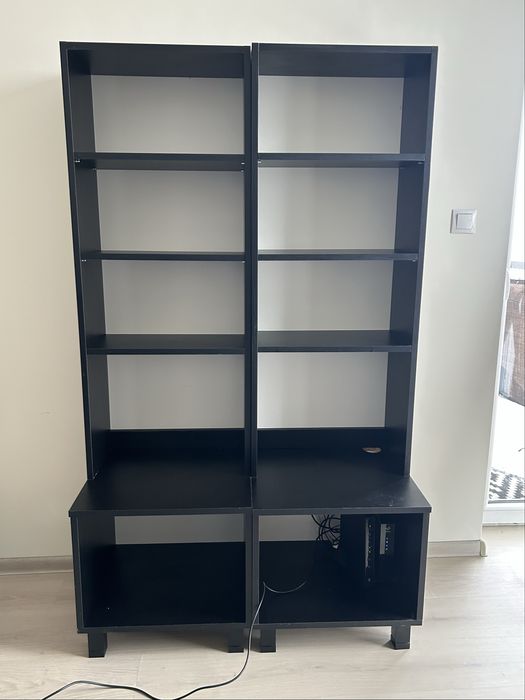 Dwa czarne regały na książki z otworem na kable na stopkach