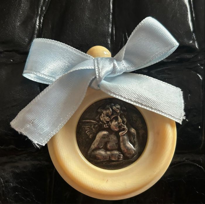 Medalhao de berco em prata e materia nobre.