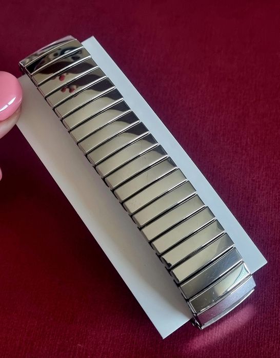 Pulseira elástica prateada, em aço inoxidável.