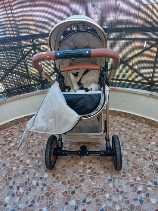 Carrinho de bebé com mmarcas de uso no puxador.