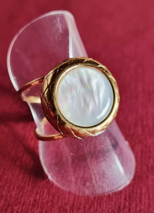 Anel dourado, em aço, com madrepérola redonda. Ajustável