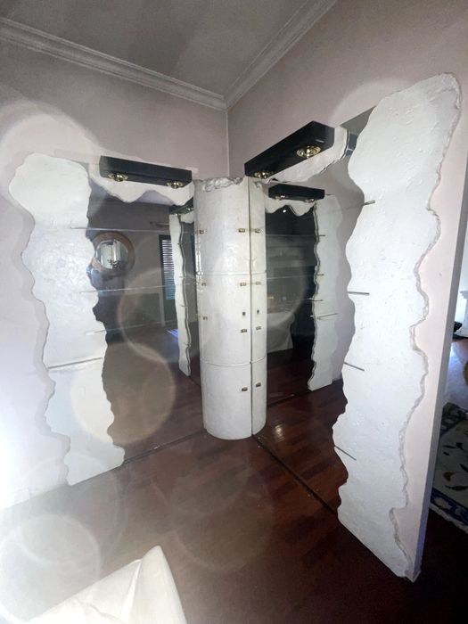 Bar de pedra com espelhos e vidros.