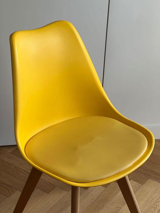 Dwa żółte krzesła na drewnianych nogach skandynawski styl