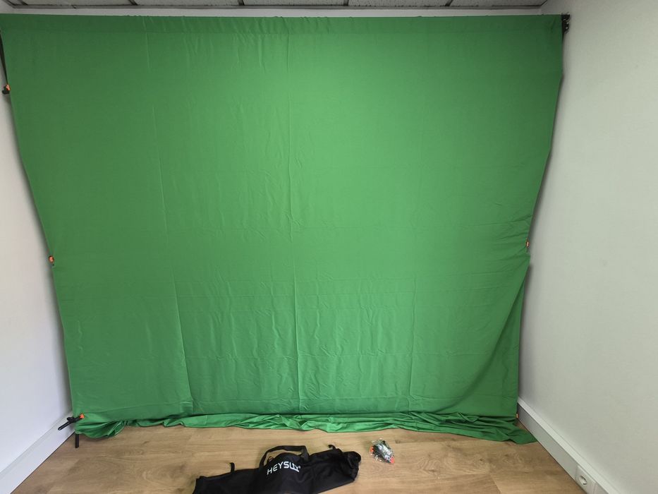 Suporte para fundo fotográfico e um tecido croma verde com clipes.