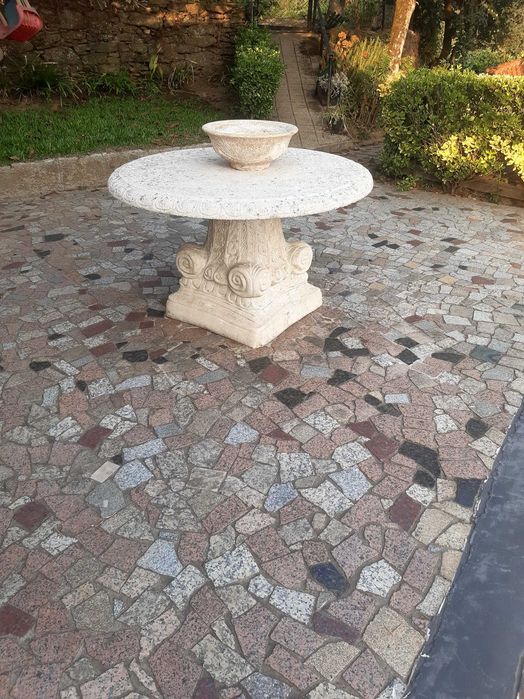 Mesa, vaso e cadeiras de jardim em pedra