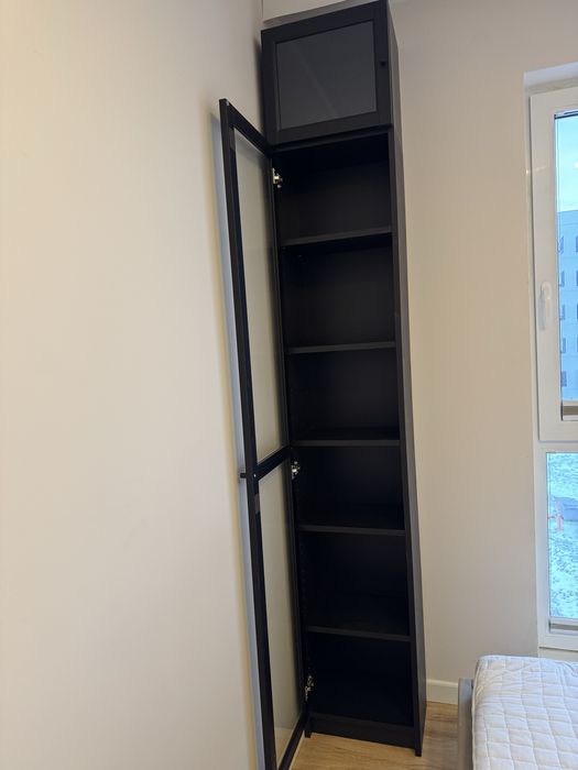 Wysoki regał z półkami na drzwiczki