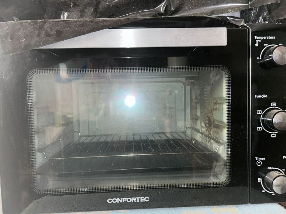 Forno  elétrico, com marcas de uso mais pegando perfeitamente