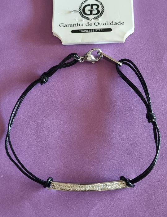 Pulseira preta e prateada, em aço. Chapinha com 2 fiadas de zirconias. Ajustável