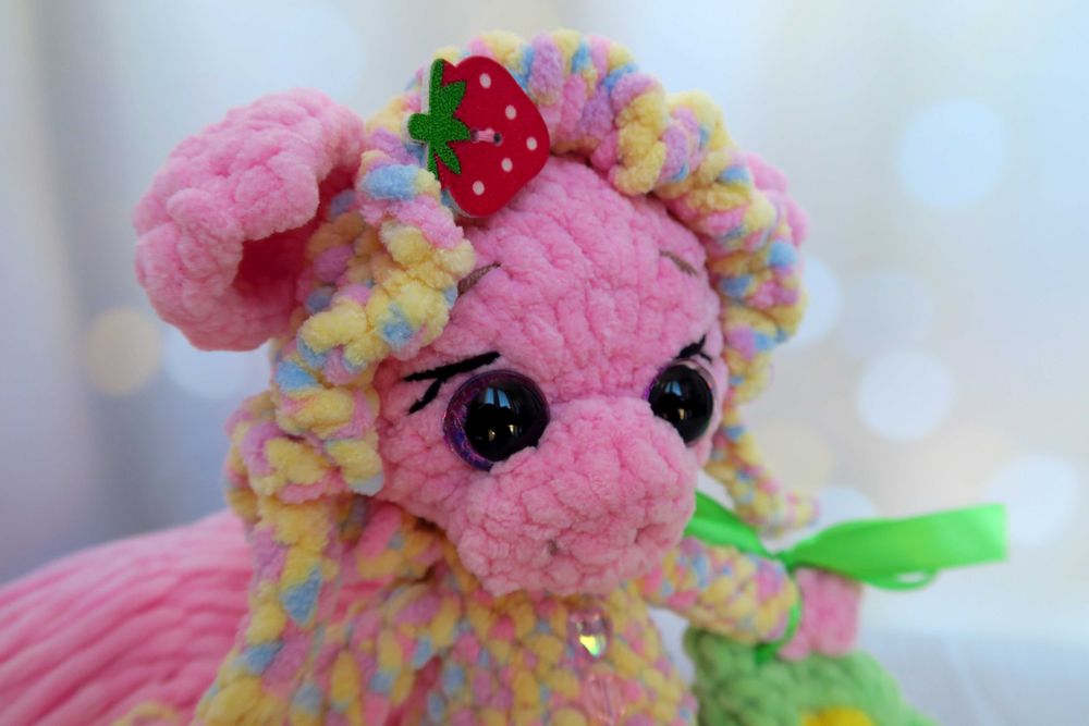 В'язана кольорова свинка в чепчику та з кукурудзою