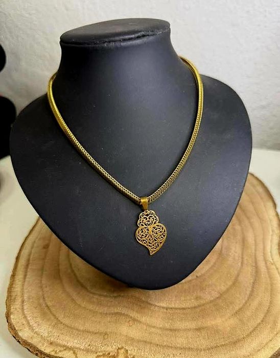 Colar dourado, em aço, malha grossa e um coração de Viana em filigrana
