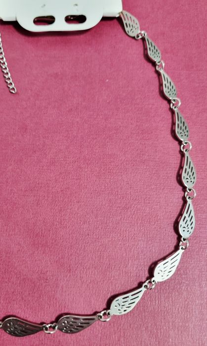 Conjunto prateado (colar e pulseira), em aço,  com asas de anjo.