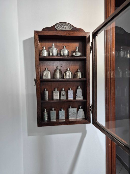 Vitrine com coleção de frascos em estanho