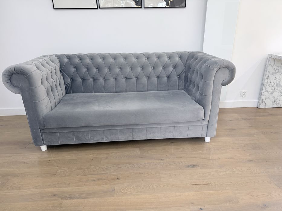 Szara sofa w stylu Chesterfield z funkcją spania
