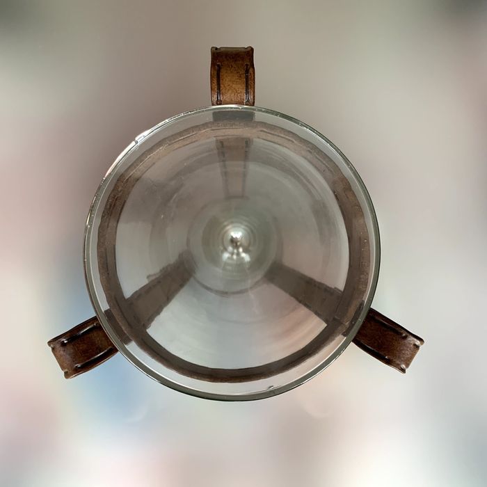 Vaso decorativo de vidro, cónico, com suporte rústico.