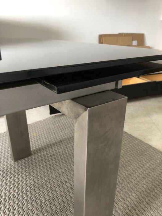 Mesa de vidro escuro, com pés em alumínio.