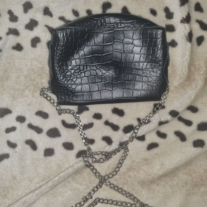 Mała czarna torebka na srebrnym łańcuszku.