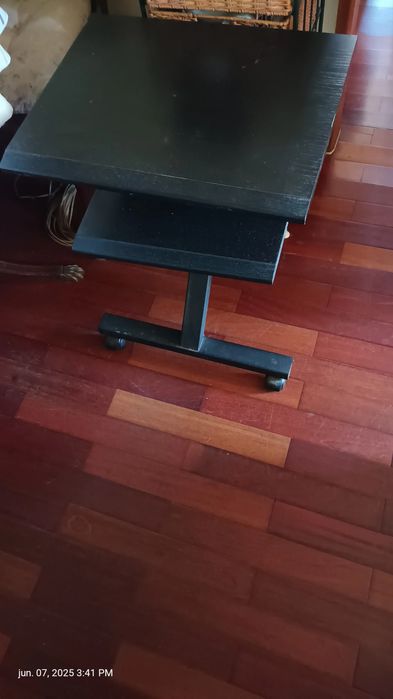 Mesa preta de televisão com rodinhas.