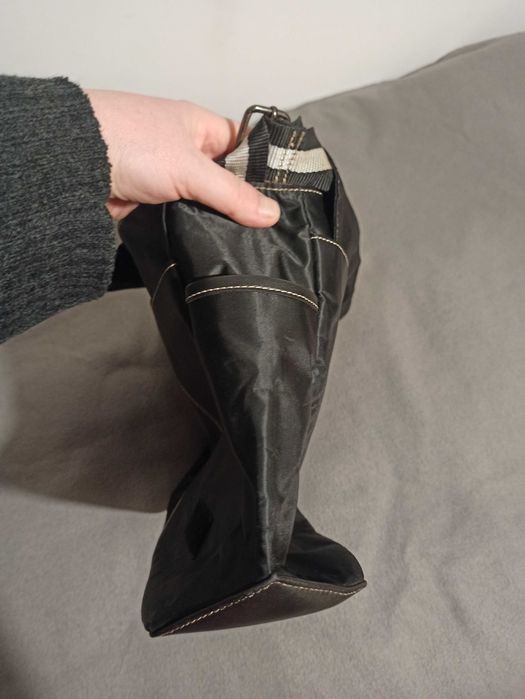 Czarna torba na ramię Nine West z klapą zapinaną na rzepy.