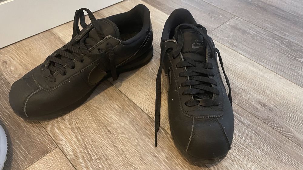Dois modelos Nike Cortez brancos e pretos