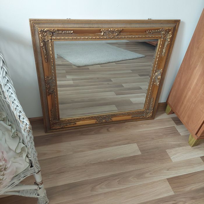 Lustro w złotej ramię.