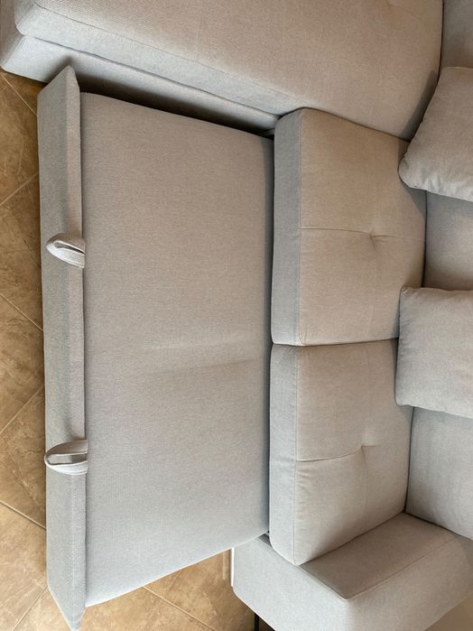 Sofá cinzento com chaise long e cama