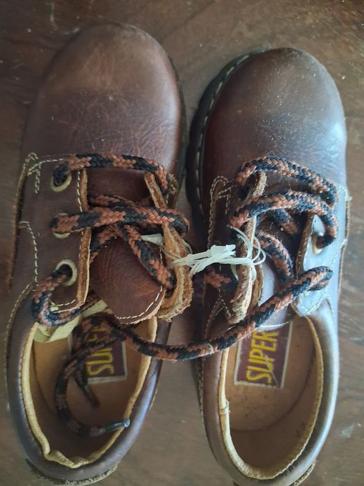 Sapatos novos de criança em pele