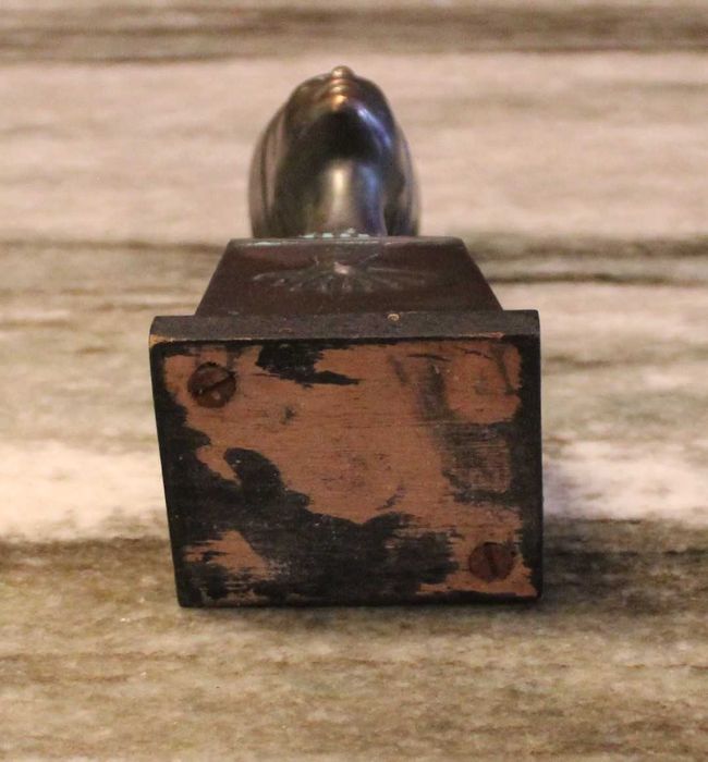 Busto de Nefertiti com 15,5cm de altura em metal sobre madeira.