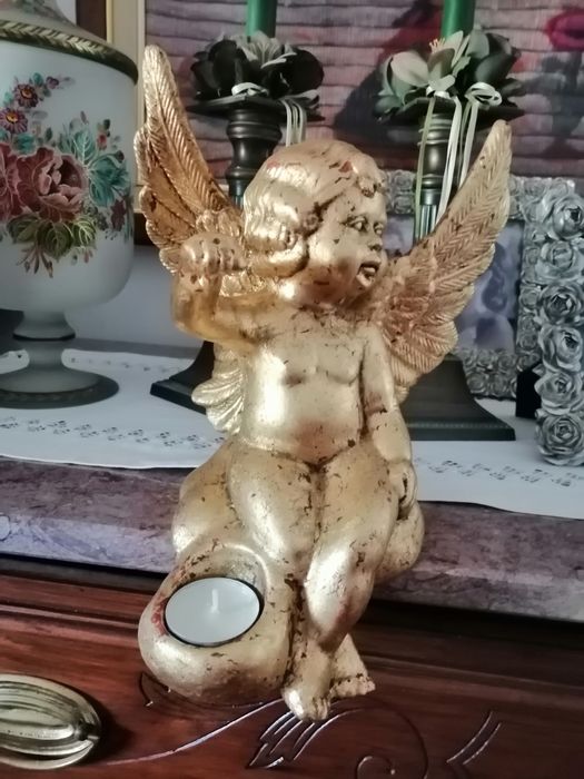 Anjo  em cerâmica coberto com folha de ouro.