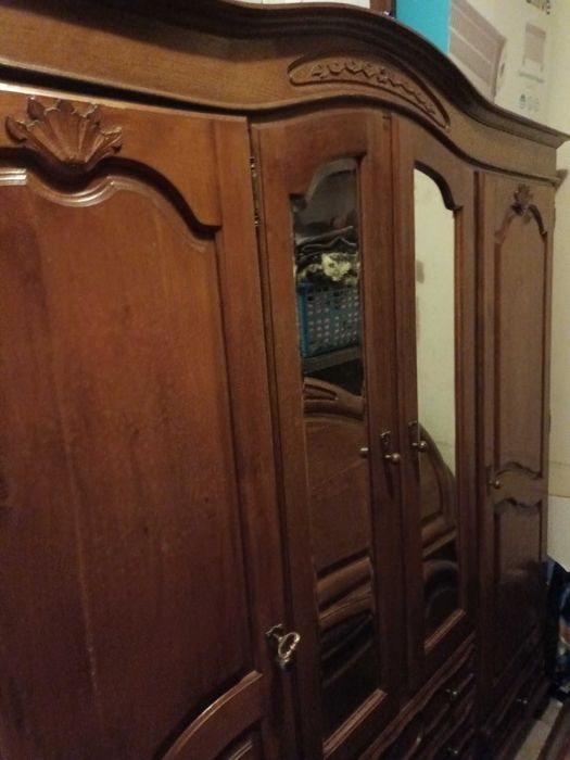 Móveis guarda vestidos, cama, cómoda e mesinhas de cabeceira.