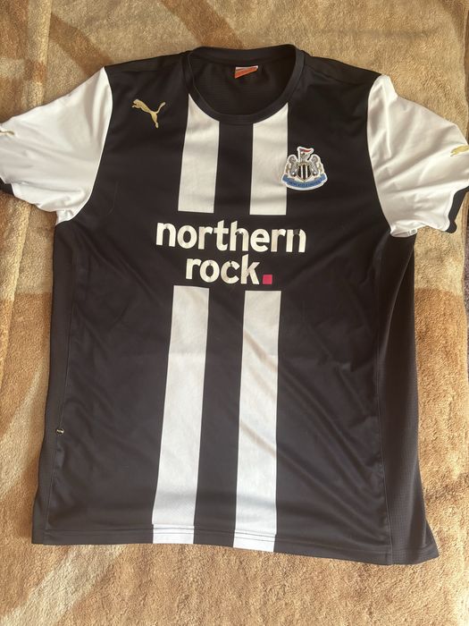 Домашня футболка Newcastle United сезону 2010/11 від Puma з золотою заклепкою лінійки Puma King та написом 1892 на спині