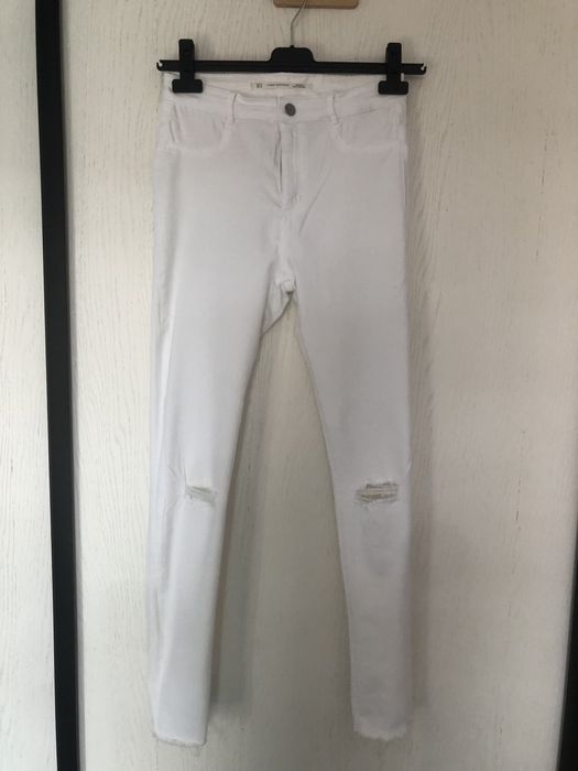 Białe spodnie z przetarciami jeans zara