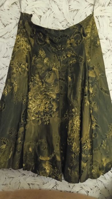 Спідниця з парчової тканини темно зеленого кольору.