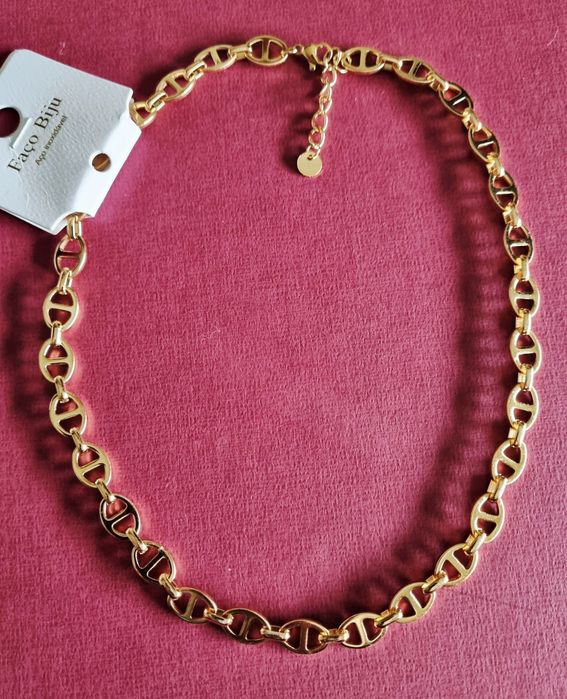 Colar/gargantilha dourada, em aço inoxidável. Tem extensor