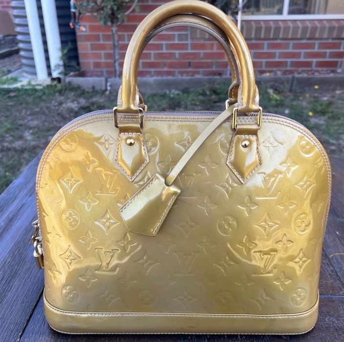 Mala  bolsa Louis Vuitton Alma PM dourada