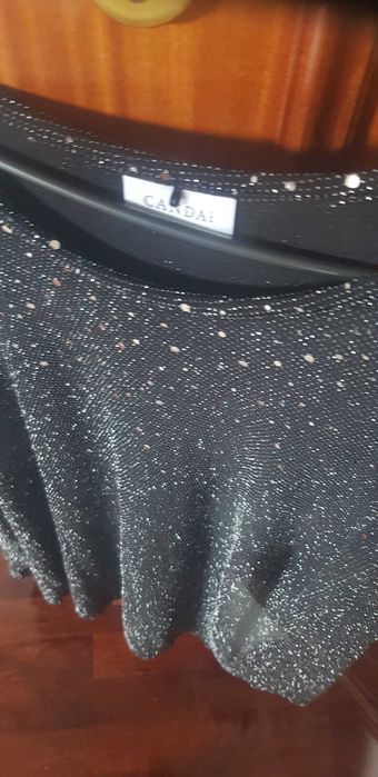 Tunica preta de malha de seda com elastano e brilhantes.