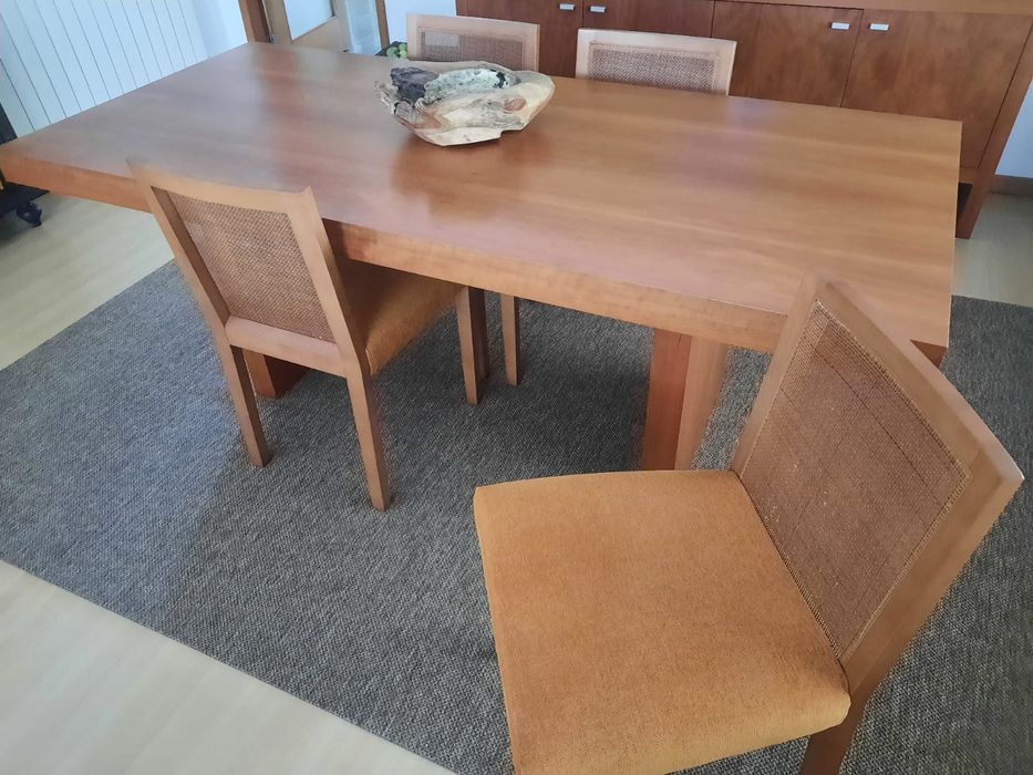 Mesa de madeira e cadeiras almofadadas