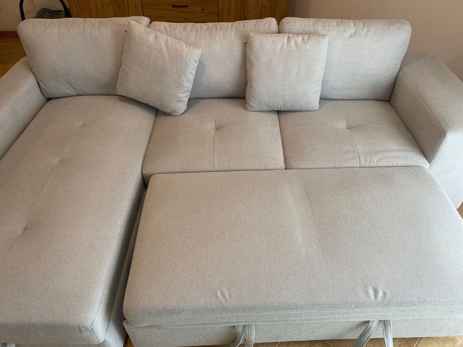 Sofá cinzento com chaise long e cama