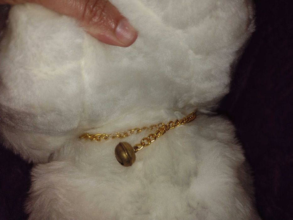 Cãozinho de peluche branco e focinho cor-de-rosa.